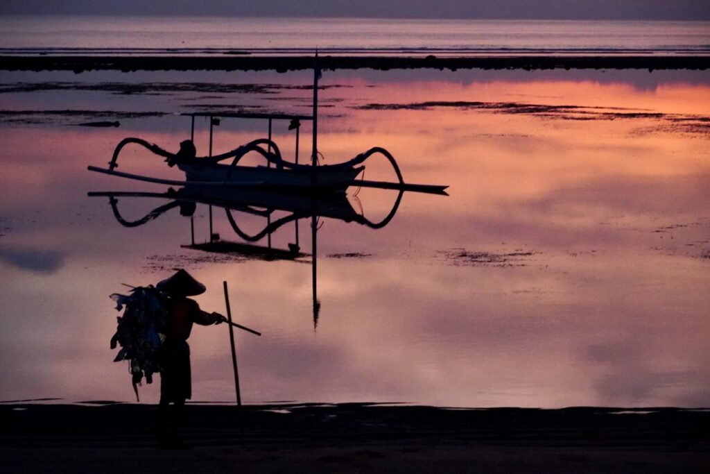 Sunrise. Fisherman heading out at low tide.